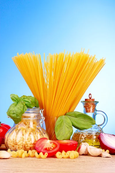 Spaghetti with garlic, onion, spices and basil on a yellow back — Stock Photo, Image
