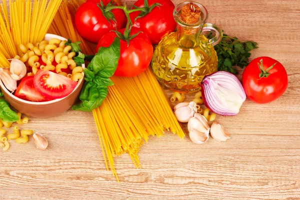Spaghetti with garlic, onion, spices and basil on a yellow back — Stock Photo, Image