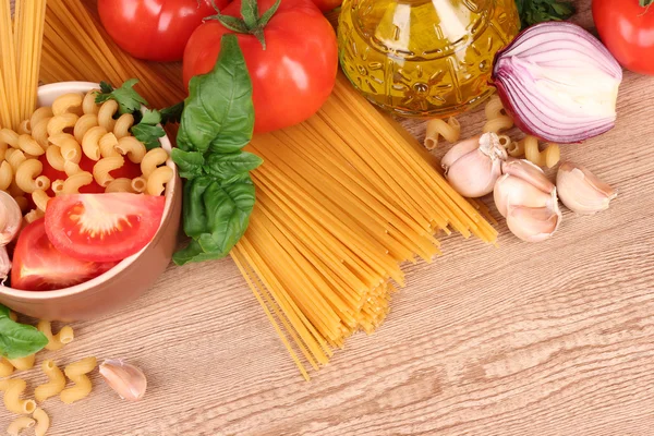 Spaghetti med vitlök, lök, kryddor och basilika på en gul tillbaka — Stockfoto