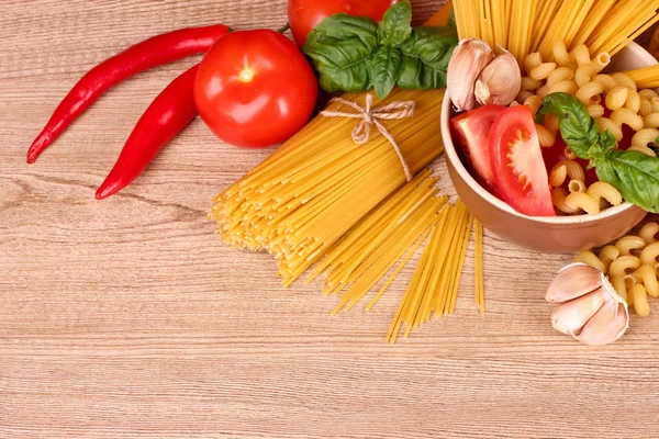 Spaghettis à l'ail, à l'oignon, aux épices et au basilic sur fond de bois — Photo