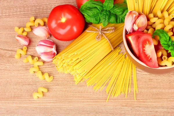 Espaguetis con ajo, cebolla, especias y albahaca en un dorso amarillo —  Fotos de Stock