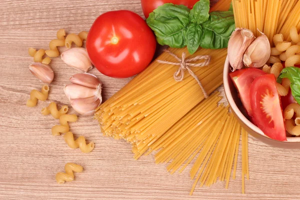 Espaguete com alho, cebola, temperos e manjericão em umas costas amarelas — Fotografia de Stock