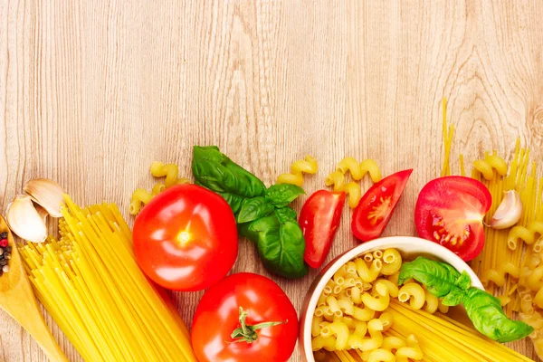 Spaghetti met knoflook, ui, kruiden en basilicum op een gele achterzijde — Stockfoto