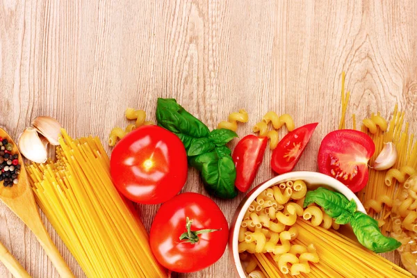Špagety s bazalkou listy, rajčata a papriky na žluté bac — Stock fotografie