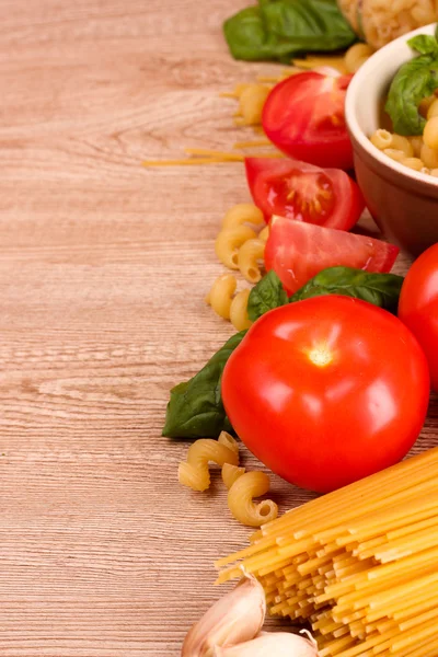 Spaghetti met knoflook, ui, kruiden en basilicum op een gele achterzijde — Stockfoto