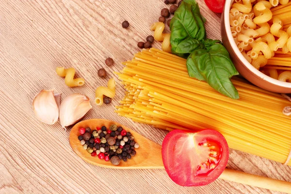 Spaghetti mit Knoblauch, Zwiebeln, Gewürzen und Basilikum auf gelbem Rücken — Stockfoto