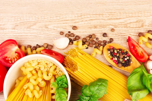 Spaghetti mit Knoblauch, Zwiebeln, Gewürzen und Basilikum auf gelbem Rücken — Stockfoto