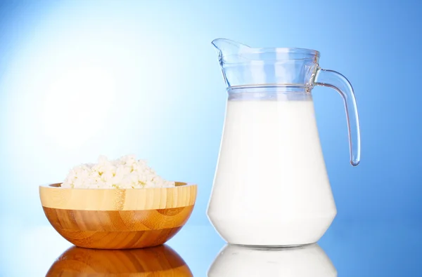 Brocca con latte e fiocchi di latte su sfondo blu con ref — Foto Stock