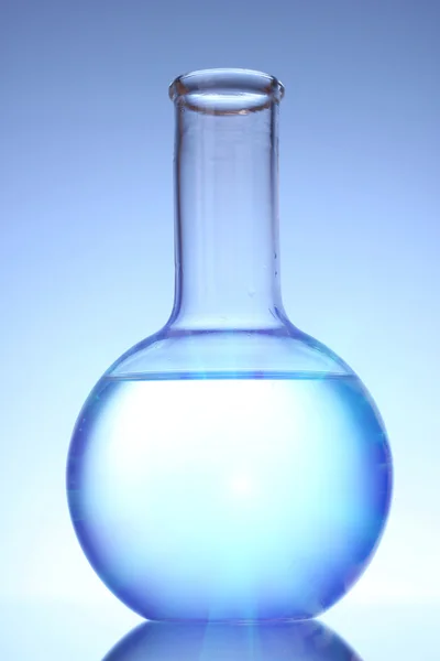 Флакон с жидкостью на синем фоне — стоковое фото
