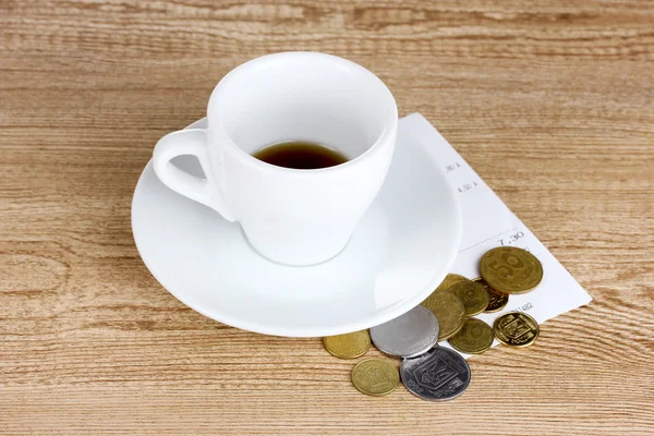 Xícara vazia de café com ponta de moedas em fundo de madeira. Ucrânia — Fotografia de Stock