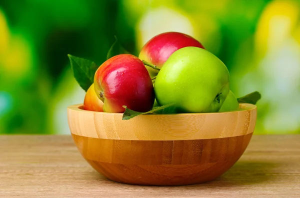 De nombreuses pommes biologiques fraîches sur une table en bois — Photo