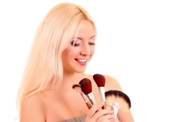 Jonge mooie vrouw met borstels voor make-up geïsoleerd op wit — Stockfoto