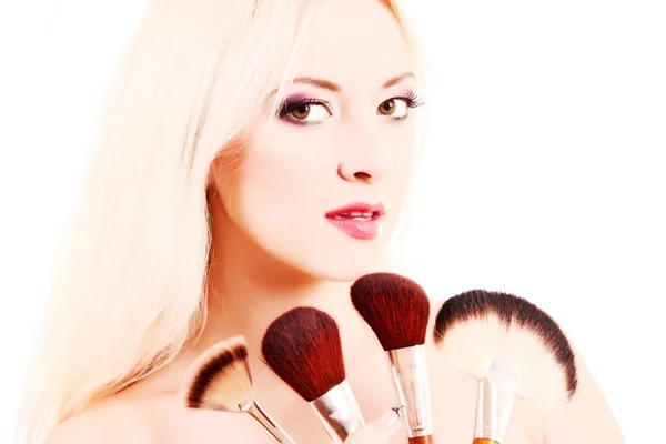 Jeune belle femme avec des pinceaux pour maquillage isolé sur blanc — Photo