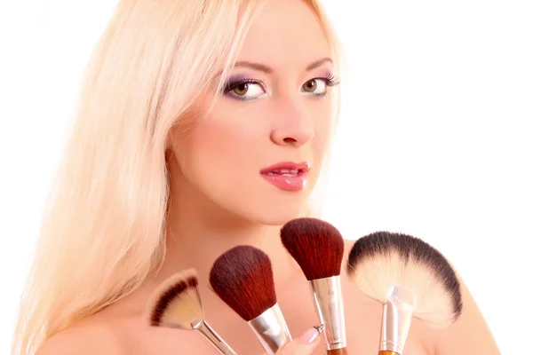 Jonge mooie vrouw met borstels voor make-up geïsoleerd op wit — Stockfoto