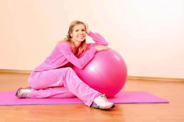 Женщина с мячом для упражнений и гантели в тренажерном зале — стоковое фото