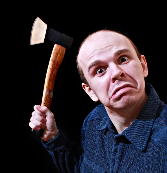 Молодой сердитый человек с топором на черном фоне — стоковое фото