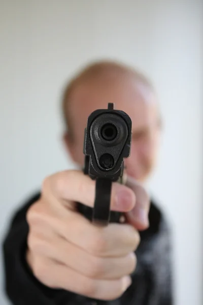 Joven apuntando con pistola en la mano — Foto de Stock