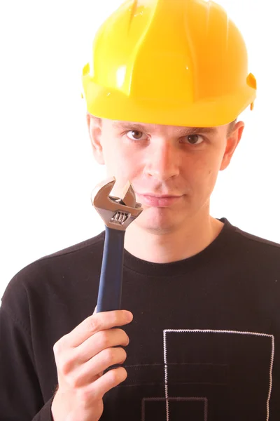 Young man with adjustable wrench in yellow helmet isolated on wh — Stock Photo, Image