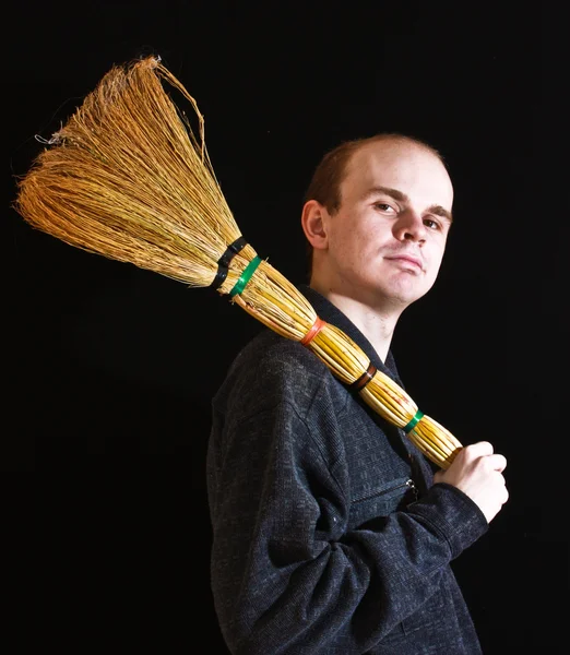 Janitor man with besom on black background — Stock Photo, Image