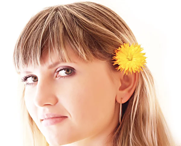 Νεαρή γυναίκα με το λουλούδι στα μαλλιά που απομονώνονται σε λευκό — Φωτογραφία Αρχείου