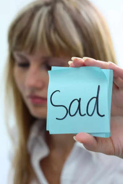 Sad girl with note pad on white background — Stock Photo, Image