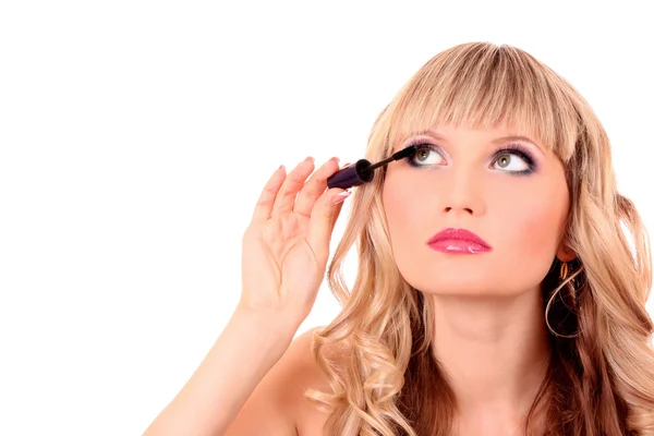 Schöne junge blonde Frau, die Mascara auf ihre Wimpern aufträgt — Stockfoto