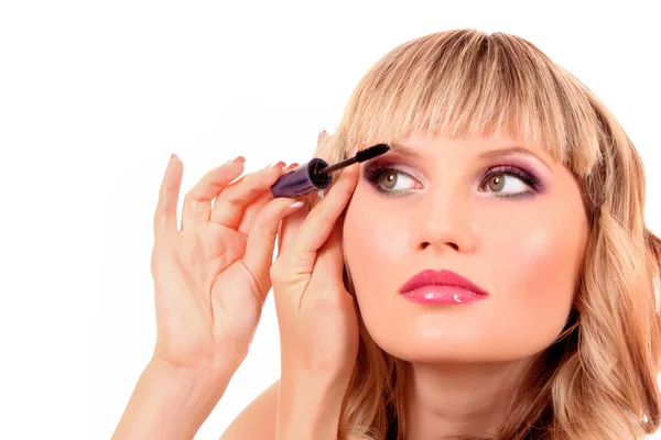 Beautiful young blonde woman applying mascara on her eyelashes — Stock Photo, Image