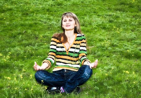 Mladá žena, která dělá jógu v parku — Stock fotografie