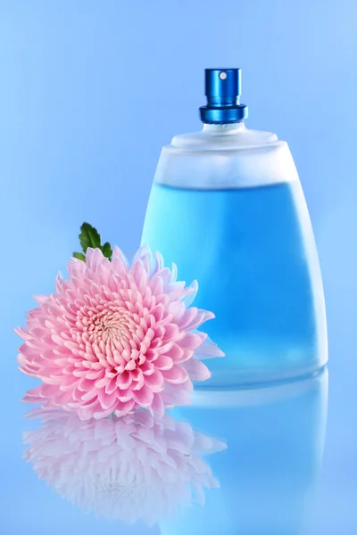 Bottiglia di profumo su sfondo blu — Foto Stock