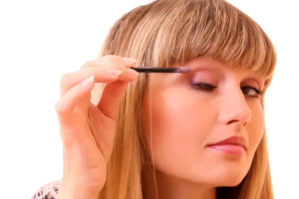 Junge Frau schminkt ihre Augenbraue isoliert auf weiß — Stockfoto