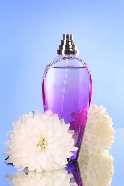 Пляшка парфумів на синьому фоні — стокове фото