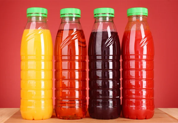 Flessen van SAP op rode achtergrond — Stockfoto