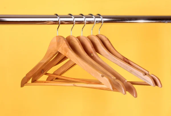 Houten kapstokken op een kleding rail — Stockfoto