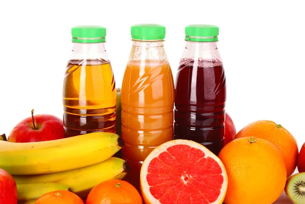 Flaskor juice med mogna frukter på vit bakgrund — Stockfoto