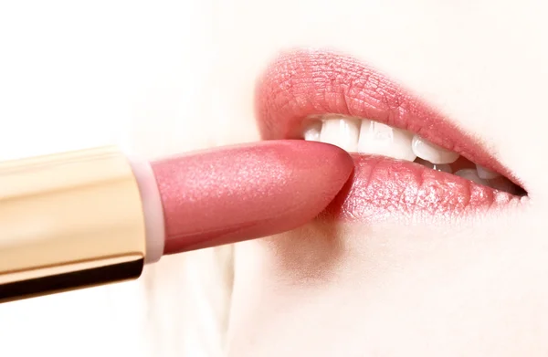 Beautiful young girl making up her lips with lipstick — Stock Photo, Image
