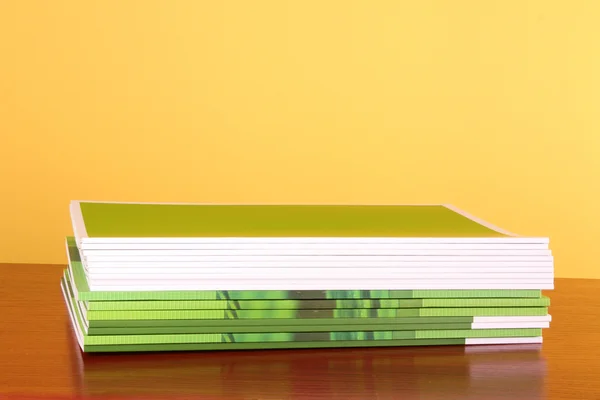 Pilha de revistas coloridas isoladas no fundo amarelo — Fotografia de Stock
