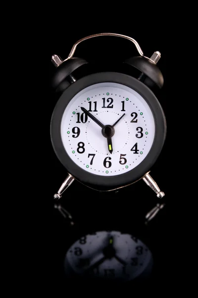 Relógio despertador sobre fundo preto com reflexão — Fotografia de Stock