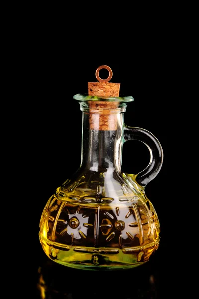 Garrafa de vidro de azeite sobre fundo preto — Fotografia de Stock