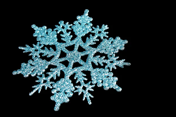 Blue shiny snowflake isolated on black — Stock Photo, Image