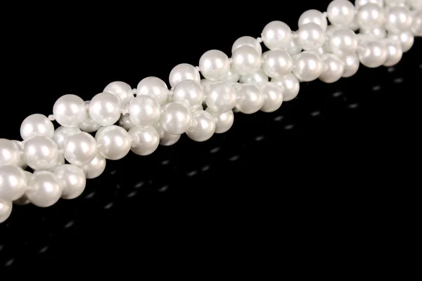 Білі перлини на чорному фоні — стокове фото