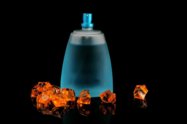 Blaue Flasche Parfüm und Edelsteine auf schwarz — Stockfoto