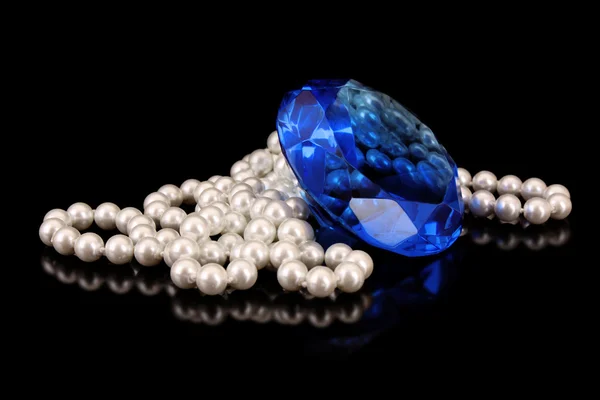 Bílé perly s velkým modrý drahokam na černém — Stock fotografie