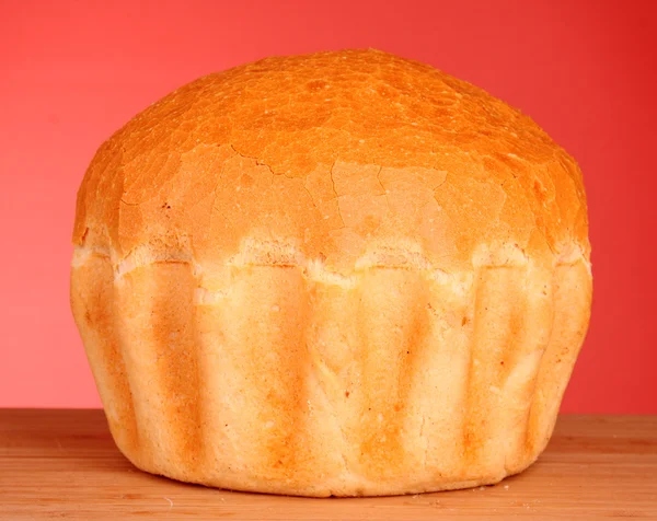 Čerstvý chléb pšenice na červeném pozadí — Stock fotografie