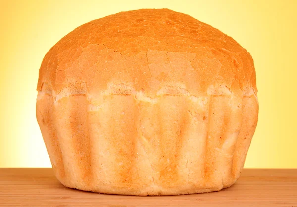 Pão de trigo fresco sobre fundo amarelo — Fotografia de Stock