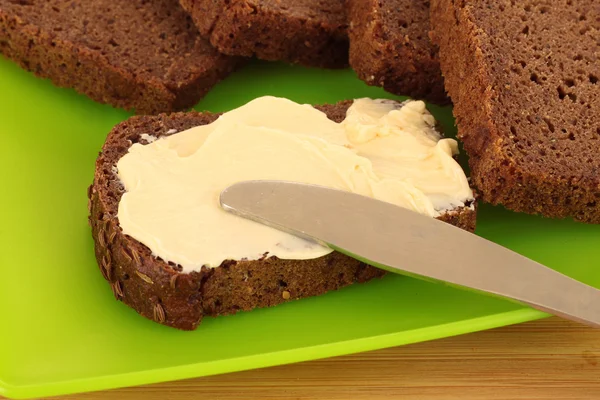 Нож и хлеб с маслом на тарелке — стоковое фото