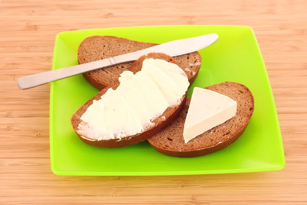 Нож и хлеб с маслом на тарелке — стоковое фото