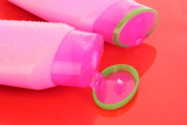 stock image Shampoo bottles on red