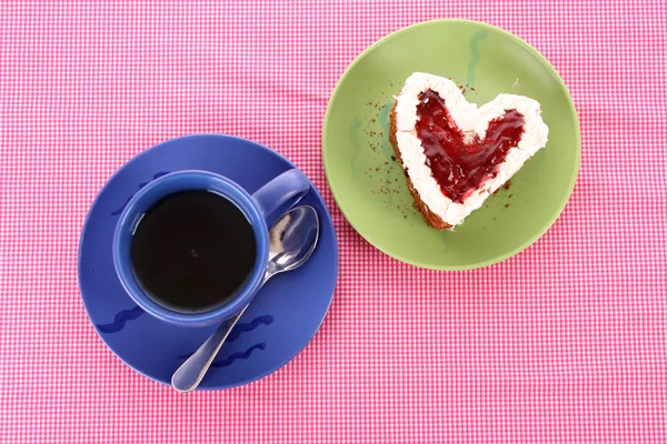 Сердце кека и чашка чая на столе — стоковое фото