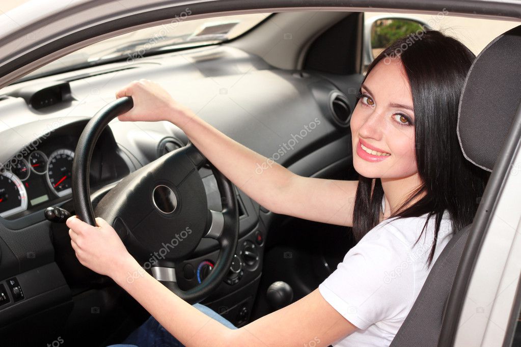 Young brunette woman in new car