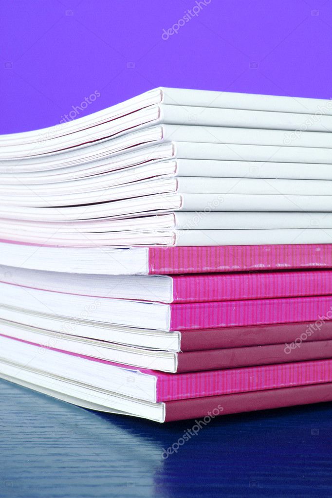 Pile of color magazines isolated on yellow background